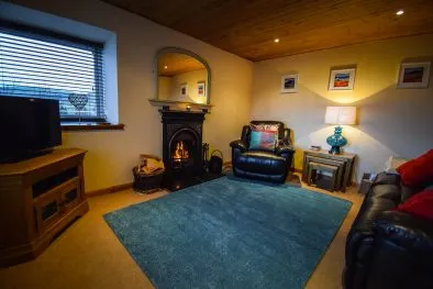 The spacious lounge with open fire at Gables Cottage, Polbain